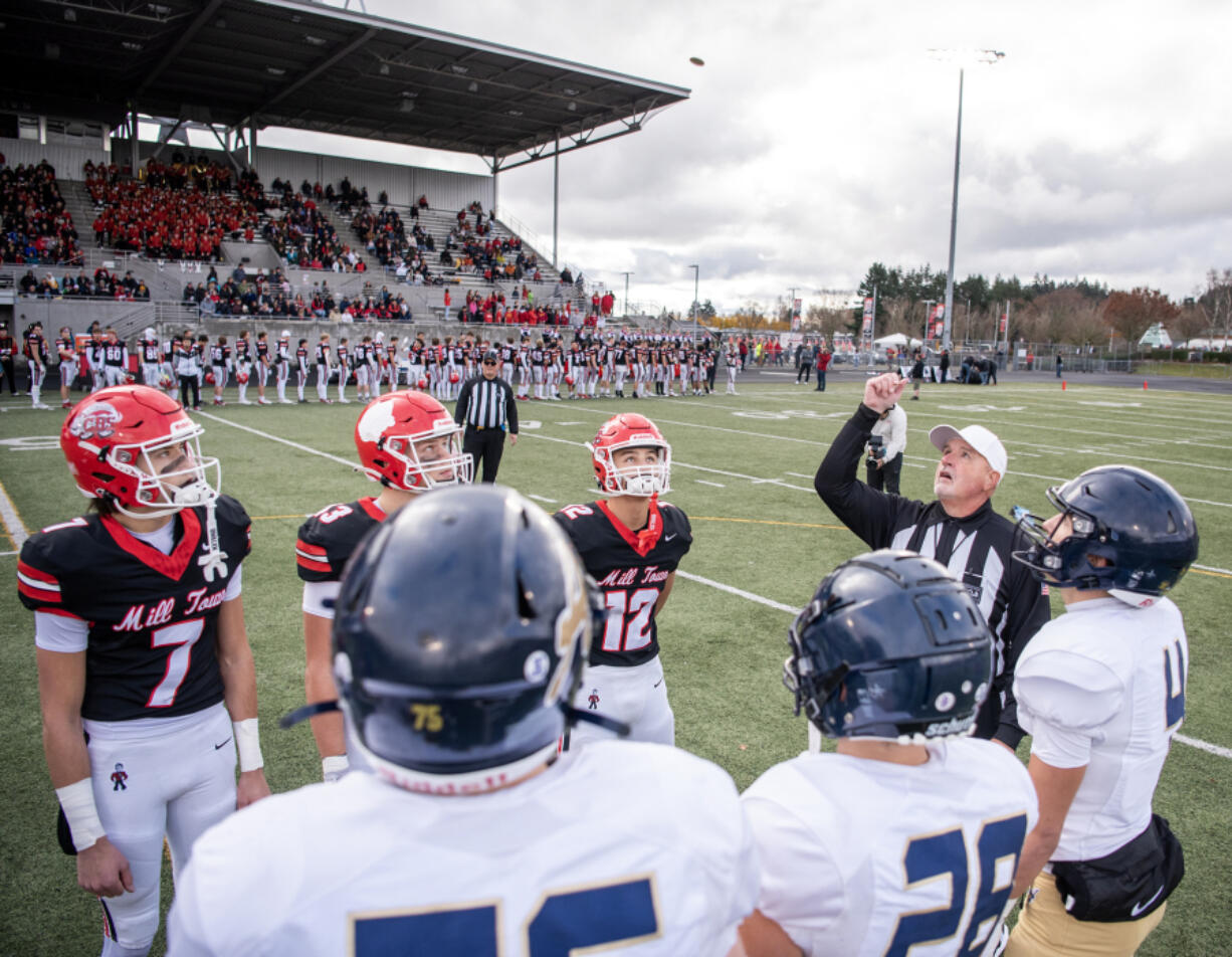 Camas, left, and Arlington captains watch the coin toss before a Class 4A state quarterfinal playoff game at Doc Harris Stadium in Camas on Saturday.