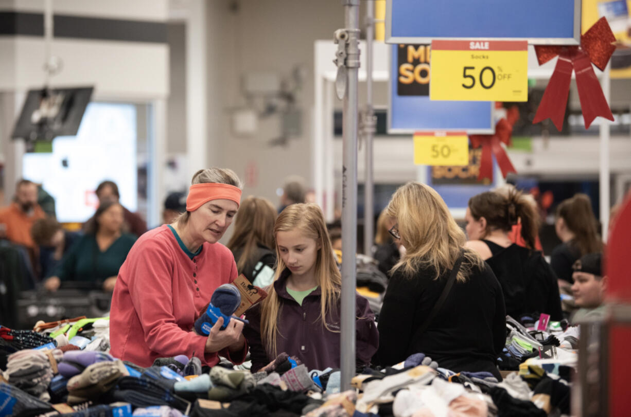 Rebecca, left, and Noelle Every, 11, browse discounted socks during Black Friday at the Fisher&rsquo;s Landing Fred Meyer.