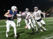 Seton Catholic senior Ryker Ruelas (5) stiff arms Montesano junior Kole Kjesbu (24) on Saturday, Nov. 30, 2024, during the Cougars’ 35-14 win against Montesano in a 1A semifinal playoff game at McKenzie Stadium.