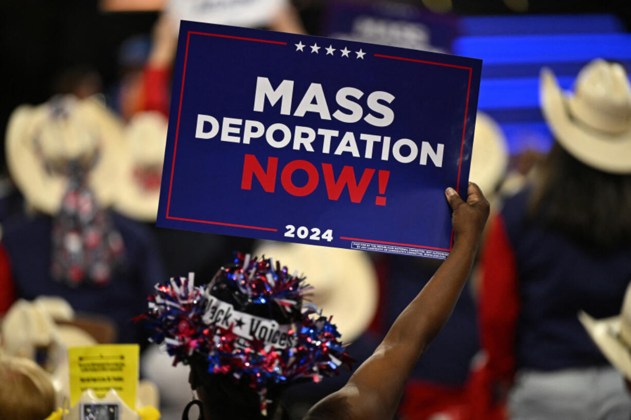 An attendee holds up a sign reading &quot;mass deportations now!&quot; during the third day of the 2024 Republican National Convention at the Fiserv Forum in Milwaukee, Wisconsin, on July 17, 2024. (Patrick T.