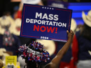 An attendee holds up a sign reading &quot;mass deportations now!&quot; during the third day of the 2024 Republican National Convention at the Fiserv Forum in Milwaukee, Wisconsin, on July 17, 2024. (Patrick T.