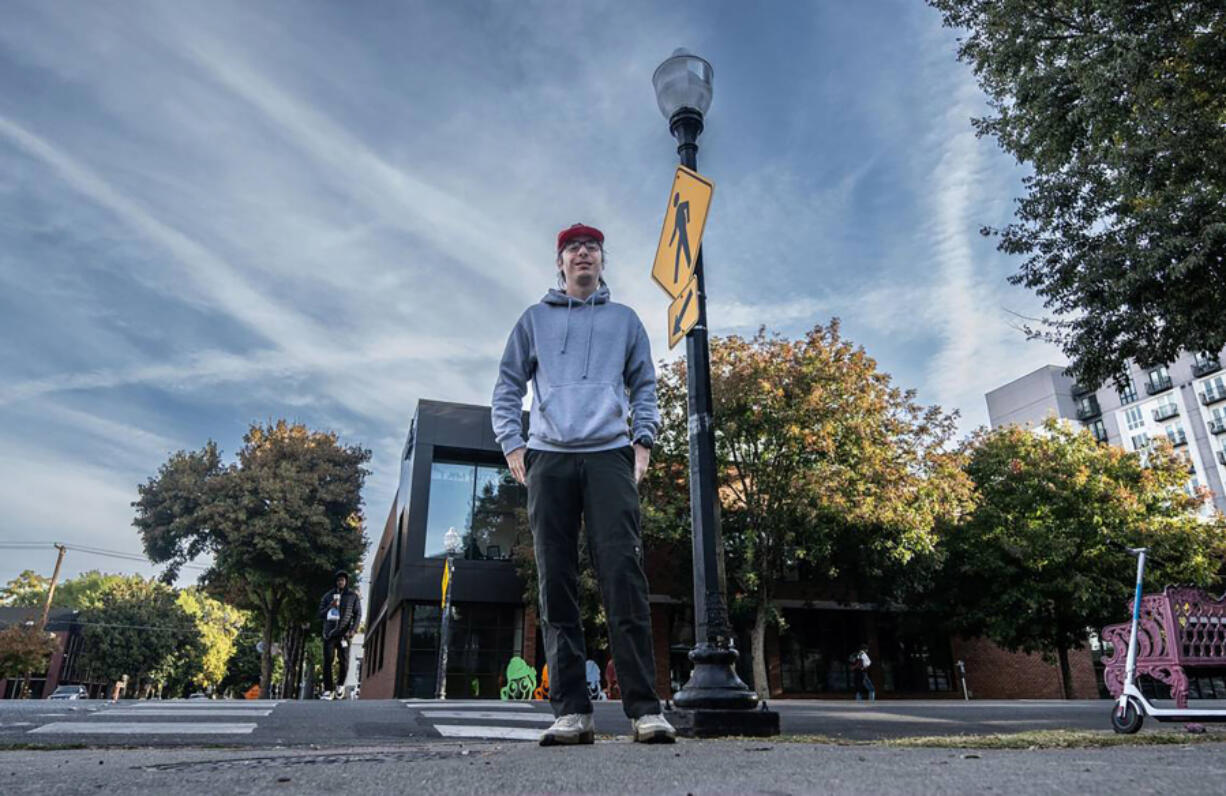 TikToker Logan Ivey stands near a street lamp on J Street in midtown Sacramento that was fixed after he featured it in a viral video. It is one of several locations that has received city attention because of his social media efforts.