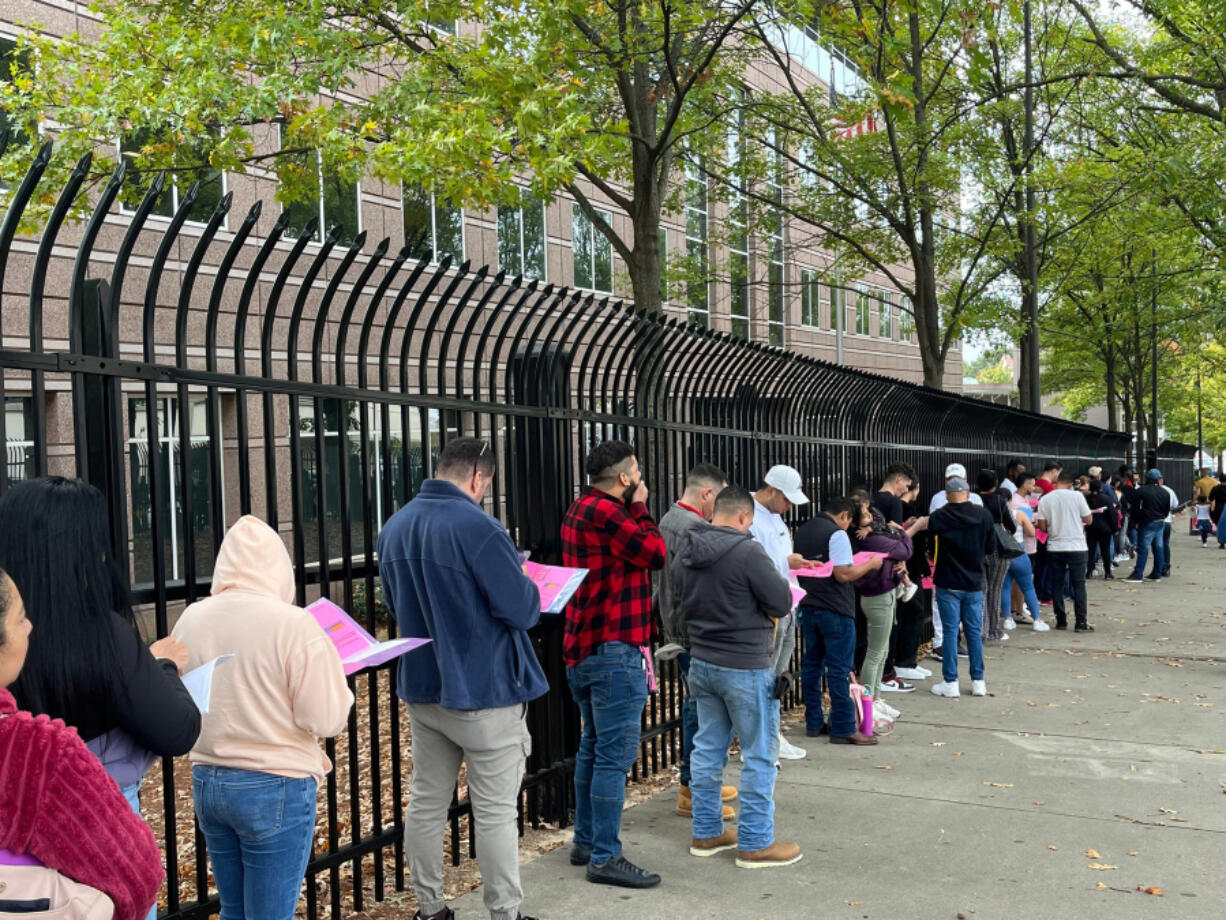 Migrants wait in line Wednesday, Nov. 6, 2024, to check in at the Atlanta field office of Immigration and Customs Enforcement.