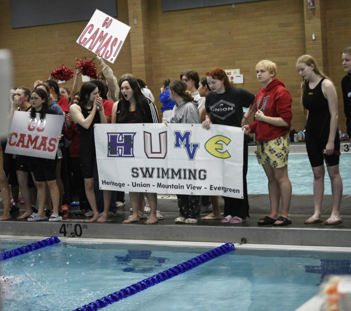 Members of the Evergreen Public Schools swim program cheer on a teammate during the 4A/3A District 4 girls swimming championships at Kelso High School on Saturday, Nov. 2, 2024.