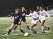 Skyview's Quinn Lundy (19) and Puyallup's Melanie Torres-Mejia (9) battle for possession of the ball during a Class 4A girls soccer state opening round game on Wednesday, Nov. 13, 2024, at Kiggins Bowl.