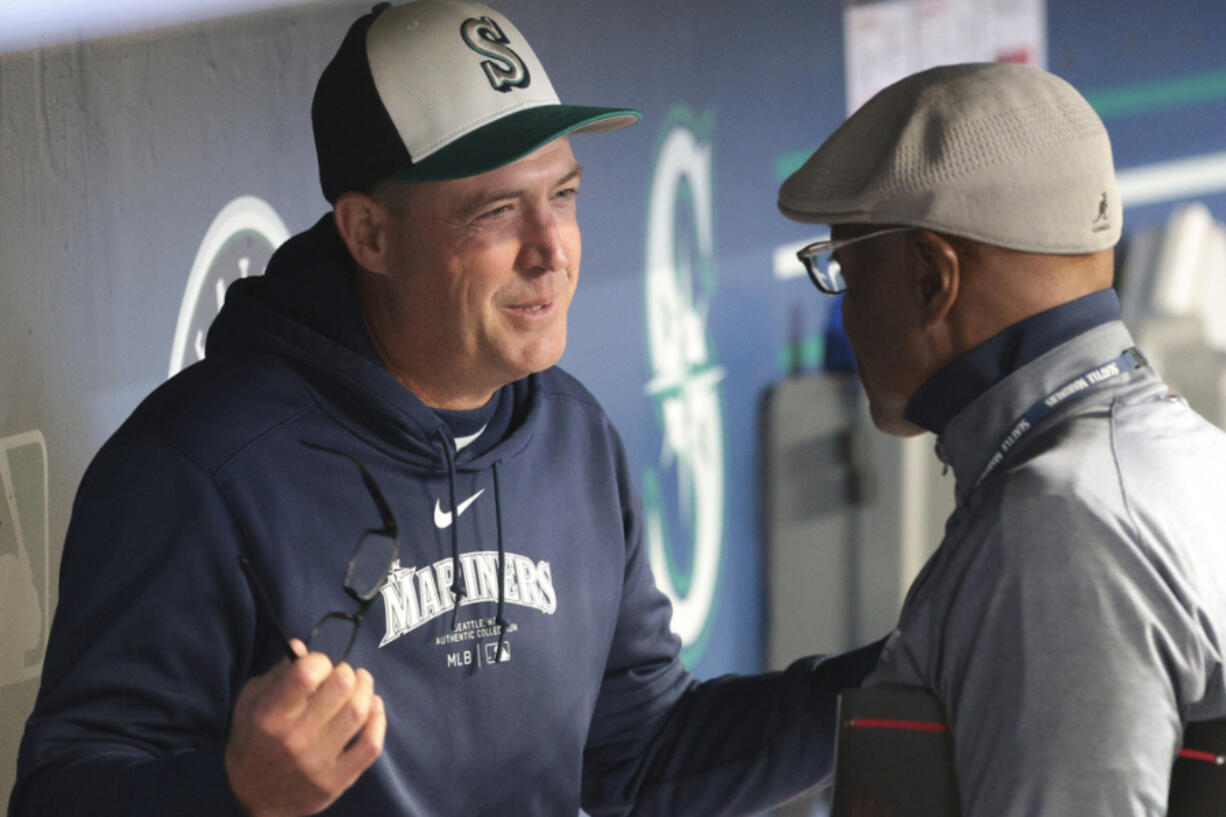 Seattle Mariners manager Dan Wilson, left, speaks with Mariners broadcaster Dave Sims before a baseball game against the San Francisco Giants, Saturday, Aug. 24, 2024, in Seattle.