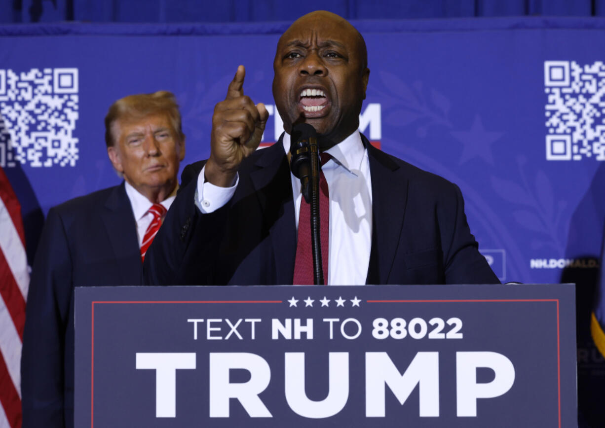 U.S. Sen. Tim Scott, R-S.C., speaks as Republican presidential candidate and former President Donald Trump looks on during a campaign rally at the Grappone Convention Center on Jan. 19, 2024, in Concord, New Hampshire.