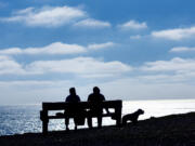 The first day of spring provided a sunny bench for a pair of hikers and their dog at Mori Point, March 19, 2024, in Pacifica, California.