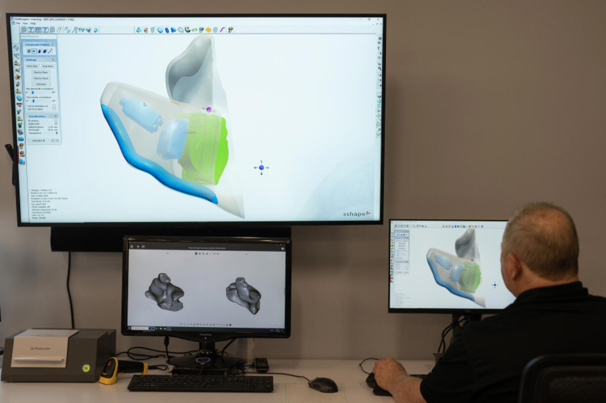 Bob Manning, senior shell design technician, demonstrates how a personalized hearing aid is modeled for an individual ear at Starkey Headquarters in Eden Prairie, Minnesota, on Thursday, Nov. 7, 2024.