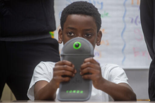 Seventh grader Kwasi Noumedor 12, holds a Yondr Pouch, which students can lock their phones during the day during school.