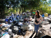 On Thursday, Nov. 7, 2024, in San Diego, Shelly Stewart and Jason Stewart walk about their property that ends near the Interstate 15 freeway. Hidden from sight by large trees and shrubs, the couple learned recently of a large and dense encampment located at the very back of their property. (Nelvin C.