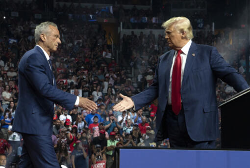 Former Republican presidential candidate Robert F. Kennedy Jr. and Republican presidential nominee, former U.S. President Donald Trump shake hands during a campaign rally at Desert Diamond Arena on Aug. 23, 2024, in Glendale, Arizona.