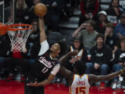 Portland Trail Blazers guard Shaedon Sharpe (17) drives to the basket as Atlanta Hawks center Clint Capela defends during the second half of an NBA basketball game, Sunday, Nov. 17, 2024, in Portland, Ore.