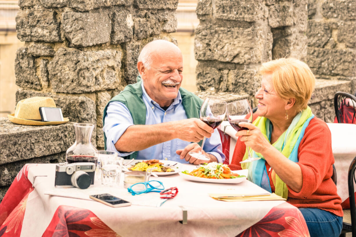 An empty-nester couple enjoys a meal at a restaurant while on vacation. New research found that two-fifths (41 percent) of American parents would rather spend money on a trip of a lifetime in 2025 than leaving inheritance to their children.