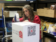 Camas-Washougal Salvation Army social services coordinator Kendra Taggart tapes up a box at the Salvation Army on Nov. 15 in Washougal.