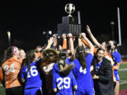 Ridgefield players hoist the Class 2A girls soccer state championship trophy after defeating Columbia River 1-0 in the championship game on Saturday, Nov. 23, 2024, at Mount Tahoma High School.