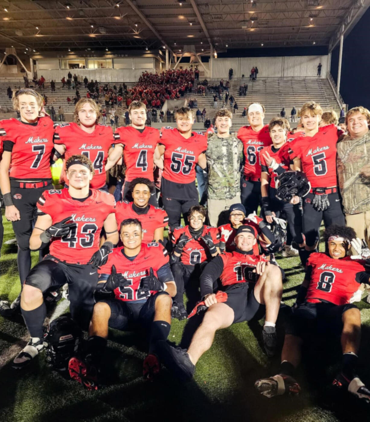 Camas football players, including several members of the East County/Camas Jets Pop Warner team pose for a photo after a game.