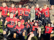 Camas football players, including several members of the East County/Camas Jets Pop Warner team pose for a photo after a game.