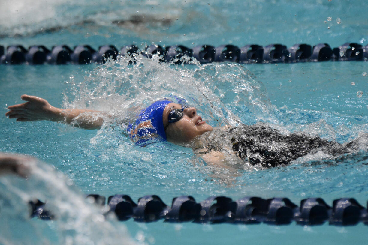 Medea Rusu of Ridgefield swims in the final of the 100-yard backstroke at the Class 2A girls swimming state championship meet at the King County Aquatic Center in Federal Way on Saturday, Nov. 16, 2024.