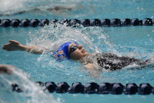 Medea Rusu of Ridgefield swims in the final of the 100-yard backstroke at the Class 2A girls swimming state championship meet at the King County Aquatic Center in Federal Way on Saturday, Nov. 16, 2024.