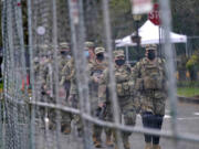 Washington National Guard members walk in formation along a perimeter fence near the Legislative Building Jan. 20, 2021, at the Capitol in Olympia. Gov, Jay Inslee has activated the Washington National Guard ahead of Election Day. (AP Photo/Ted S.