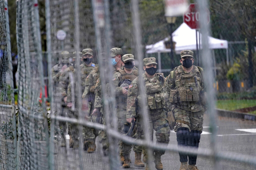 Washington National Guard members walk in formation along a perimeter fence near the Legislative Building Jan. 20, 2021, at the Capitol in Olympia. Gov, Jay Inslee has activated the Washington National Guard ahead of Election Day. (AP Photo/Ted S.