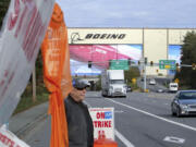 Union machinist Terry Muriekes waves a Halloween-decorated strike sign by Boeing's Everett, Wash., factory on Tuesday, Oct. 22, 2024.