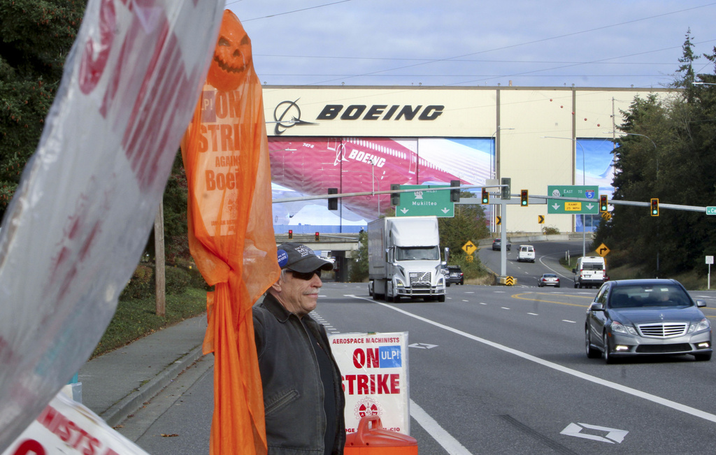 Union machinist Terry Muriekes waves a Halloween-decorated strike sign by Boeing's Everett, Wash., factory on Tuesday, Oct. 22, 2024.