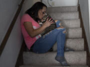 April Youst kisses her cat, Bully, on the stairs in her West Virginia home, Wednesday, Oct. 9, 2024.