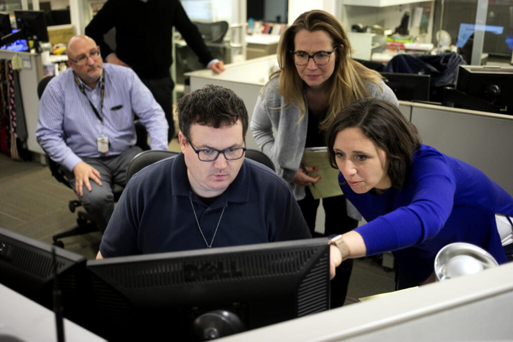 FILE - Associated Press Washington Bureau Chief Julie Pace, right, looks over a headline with deputy managing editor for operations David Scott in the newsroom at the Associated Press in Washington, Feb. 5, 2020.