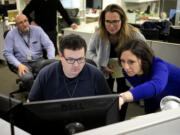 FILE - Associated Press Washington Bureau Chief Julie Pace, right, looks over a headline with deputy managing editor for operations David Scott in the newsroom at the Associated Press in Washington, Feb. 5, 2020.