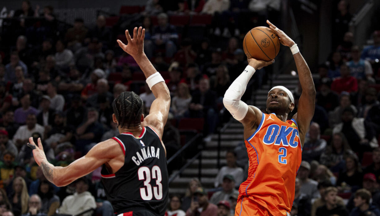 Oklahoma City Thunder guard Shai Gilgeous-Alexander, right, shoots the ball against Portland Trail Blazers forward Toumani Camara, left, during the second half of an NBA basketball game Friday, Nov. 1, 2024, in Portland, Ore.