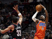 Oklahoma City Thunder guard Shai Gilgeous-Alexander, right, shoots the ball against Portland Trail Blazers forward Toumani Camara, left, during the second half of an NBA basketball game Friday, Nov. 1, 2024, in Portland, Ore.