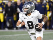 Oregon quarterback Dillon Gabriel scrambles out of the pocket against Michigan in the second half of an NCAA college football game, Saturday, Nov. 2, 2024, in Ann Arbor, Mich. Oregon defeated Michigan 38-17.