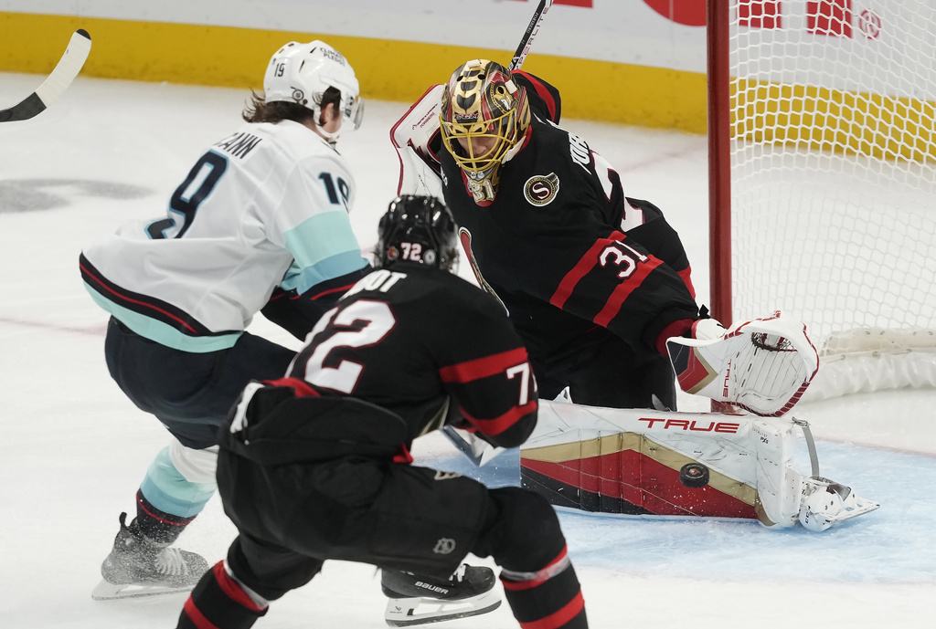 Ottawa Senators goaltender Anton Forsberg makes a save on Seattle Kraken left wing Jared McCann as Senators defenseman Thomas Chabot defends during the third period of an NHL hockey game, Saturday, Nov. 2, 2024, in Ottawa.