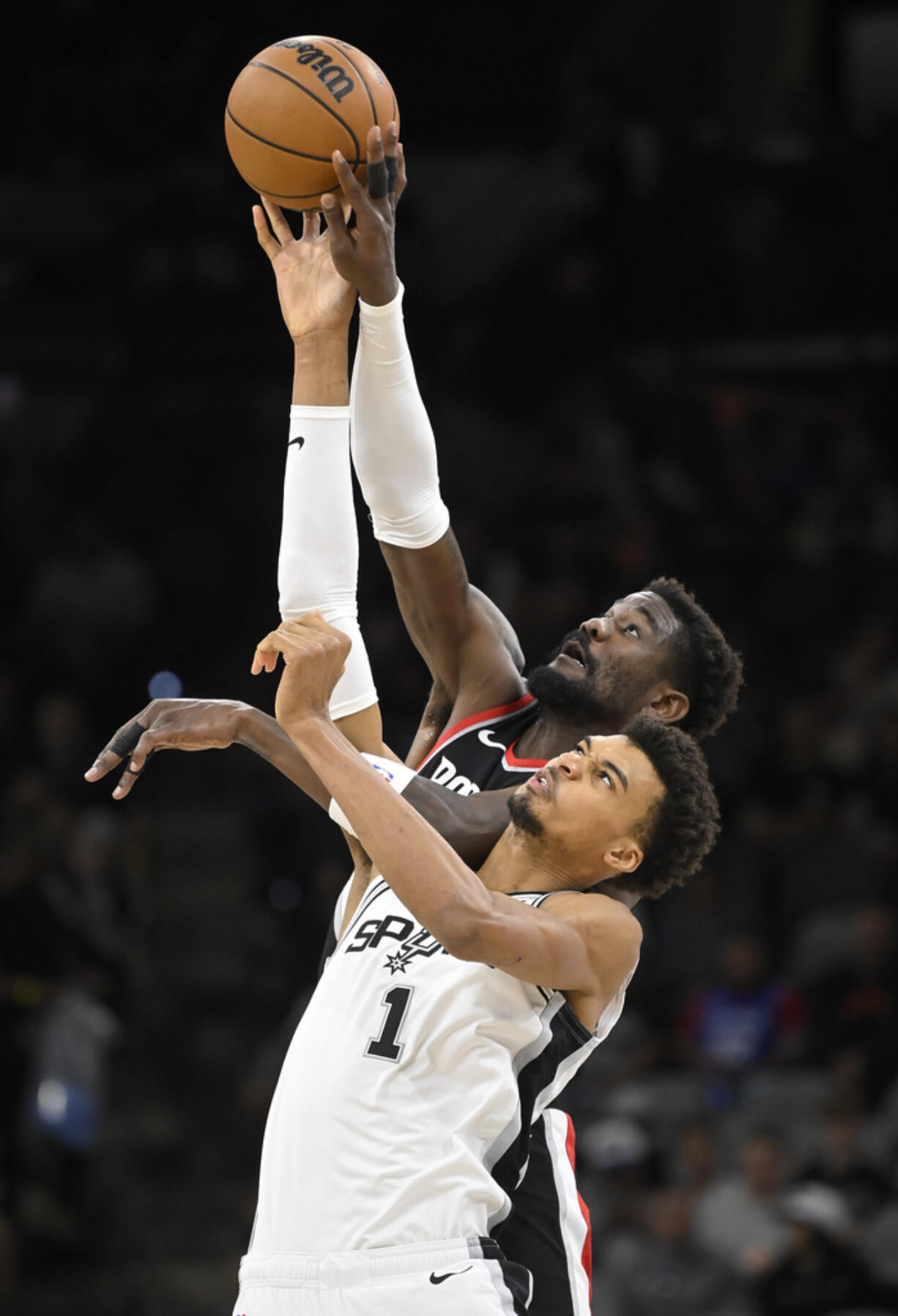 San Antonio Spurs' Victor Wembanyama (1) and Portland Trail Blazers' Deandre Ayton reach for the jump ball at the start of an NBA basketball game, Thursday, Nov. 7, 2024, in San Antonio.