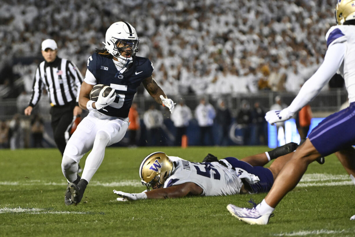 Penn State wide receiver Omari Evans (5) eludes Washington's Voi Tunuufi, center bottom, during the second quarter of an NCAA college football game Saturday, Nov. 9, 2024, in State College, Pa.