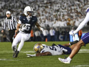 Penn State wide receiver Omari Evans (5) eludes Washington's Voi Tunuufi, center bottom, during the second quarter of an NCAA college football game Saturday, Nov. 9, 2024, in State College, Pa.