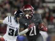 Washington State running back Wayshawn Parker (21) carries the ball during the first half of an NCAA college football game against Utah State, Saturday, Nov. 9, 2024, in Pullman, Wash.