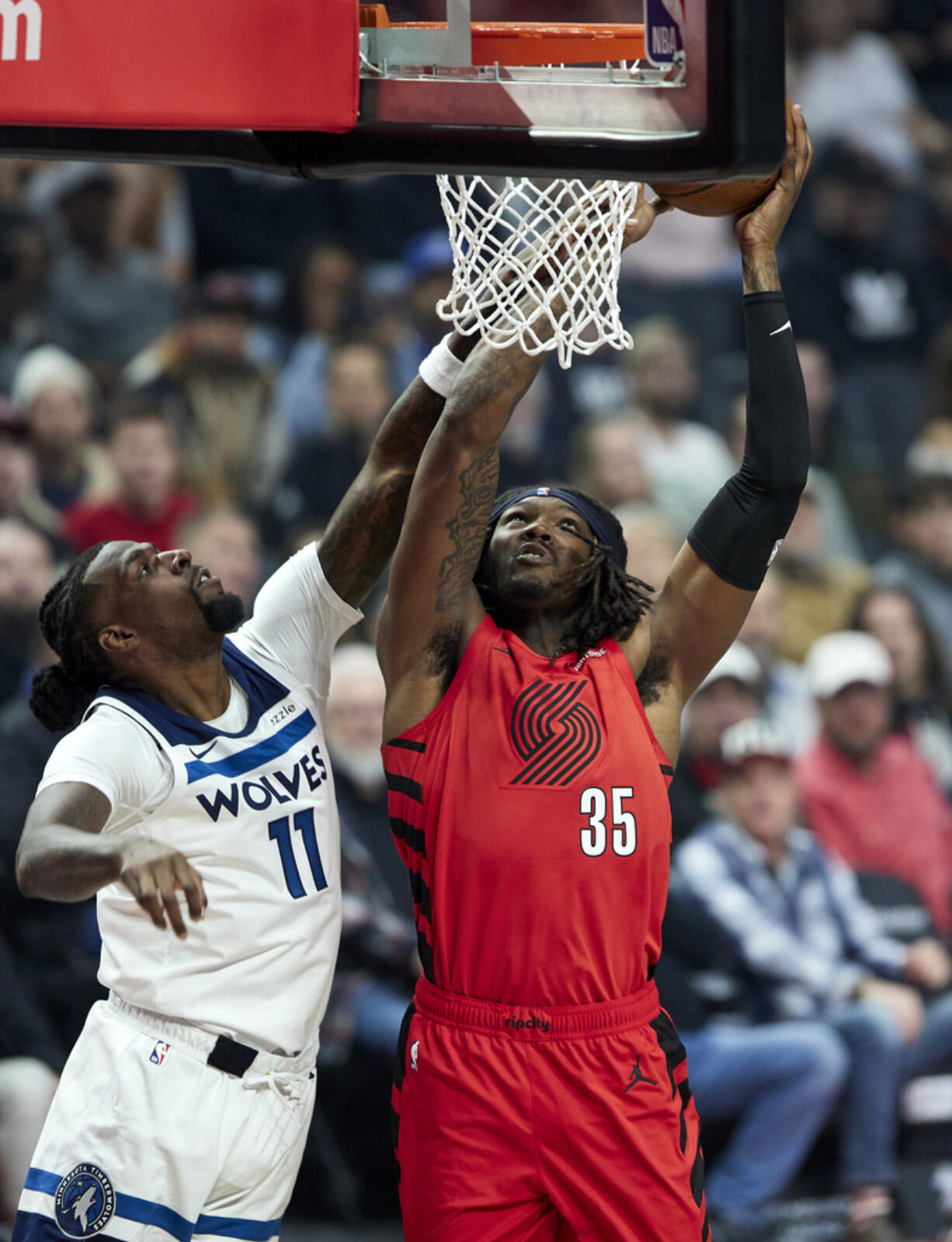 Portland Trail Blazers center Robert Williams III, right, shoots over Minnesota Timberwolves center Naz Reid during the first half of an Emirates NBA Cup basketball game in Portland, Ore., Tuesday, Nov. 12, 2024.