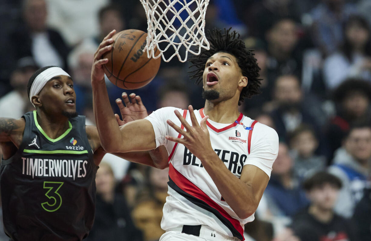 Portland Trail Blazers guard Shaedon Sharpe, right, shoots over Minnesota Timberwolves forward Jaden McDaniels during the first half of an NBA basketball game in Portland, Ore., Wednesday, Nov. 13, 2024.