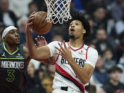 Portland Trail Blazers guard Shaedon Sharpe, right, shoots over Minnesota Timberwolves forward Jaden McDaniels during the first half of an NBA basketball game in Portland, Ore., Wednesday, Nov. 13, 2024.