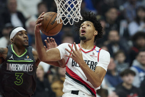 Portland Trail Blazers guard Shaedon Sharpe, right, shoots over Minnesota Timberwolves forward Jaden McDaniels during the first half of an NBA basketball game in Portland, Ore., Wednesday, Nov. 13, 2024. (AP Photo/Craig Mitchelldyer)