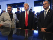 FILE - Republican presidential nominee former President Donald Trump, center, listens to Albert Abbas, owner of The Great Commoner, left, as Massad Boulos looks on during a visit to the cafe, Nov. 1, 2024, in Dearborn, Mich.