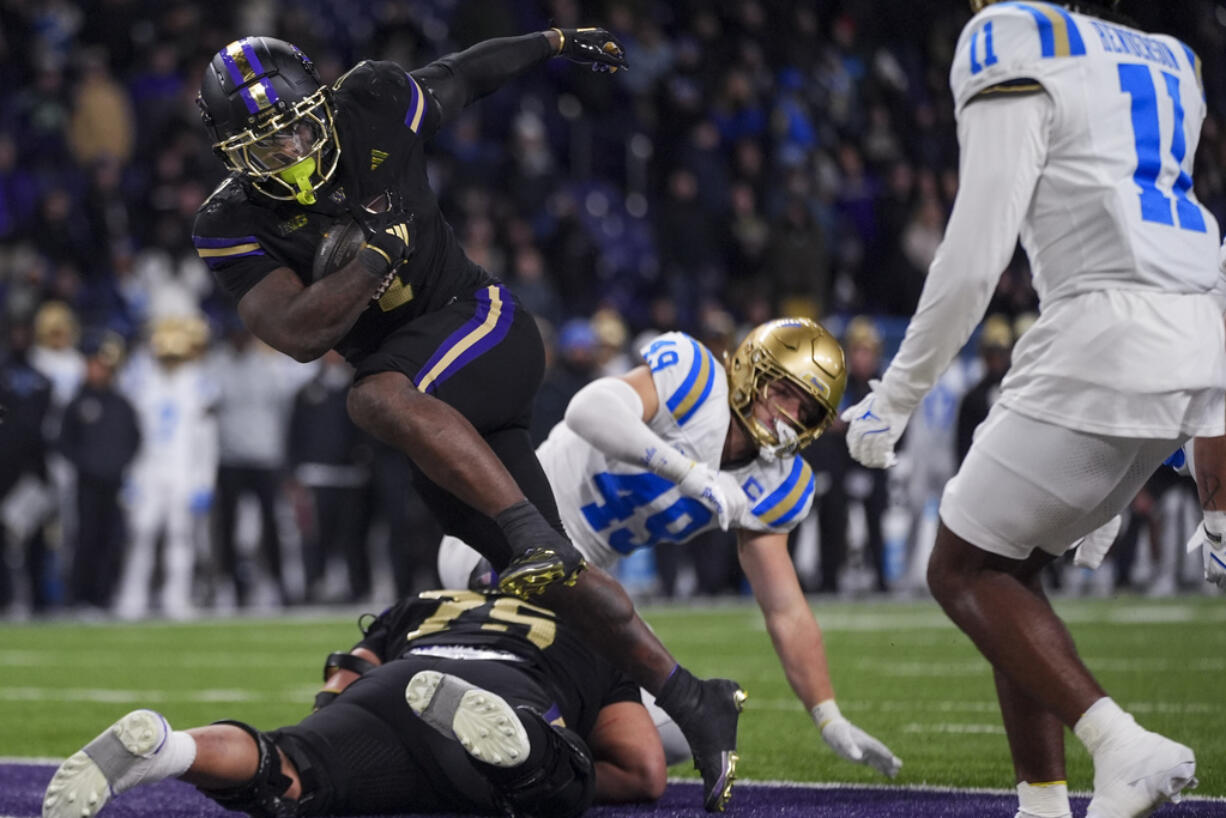 Washington running back Jonah Coleman runs in a touchdown as UCLA linebacker Carson Schwesinger (49) and Ramon Henderson (11) look on during the second half of an NCAA college football game Friday, Nov. 15, 2024, in Seattle. Washington won 31-19.