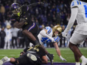 Washington running back Jonah Coleman runs in a touchdown as UCLA linebacker Carson Schwesinger (49) and Ramon Henderson (11) look on during the second half of an NCAA college football game Friday, Nov. 15, 2024, in Seattle. Washington won 31-19.