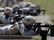 FILE - Female soldiers from 1st Brigade Combat Team, 101st Airborne Division train on a firing range while testing new body armor in Fort Campbell, Ky., Sept. 18, 2012.