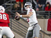 Washington State's quarterback John Mateer (10) looks to pass as he avoids the rush from New Mexico's Garrison Walker (96) during an NCAA college football game Saturday Nov. 16, 2024, in Albuquerque, N.M. (AP Photo/Roberto E.