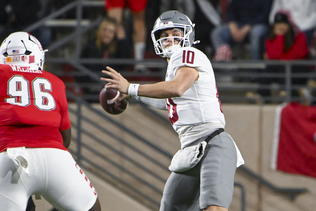 Washington State's quarterback John Mateer (10) looks to pass as he avoids the rush from New Mexico's Garrison Walker (96) during an NCAA college football game Saturday Nov. 16, 2024, in Albuquerque, N.M. (AP Photo/Roberto E.