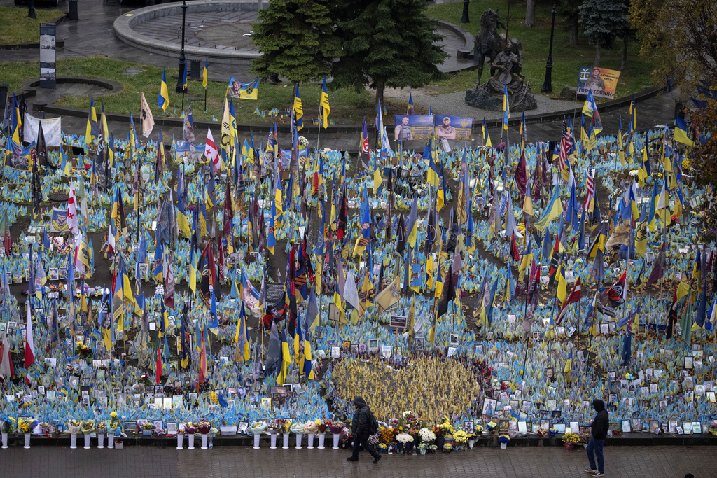 People walk past the memorial to fallen soldiers in Independence Square in Kyiv, Ukraine, Friday, Nov. 15, 2024.